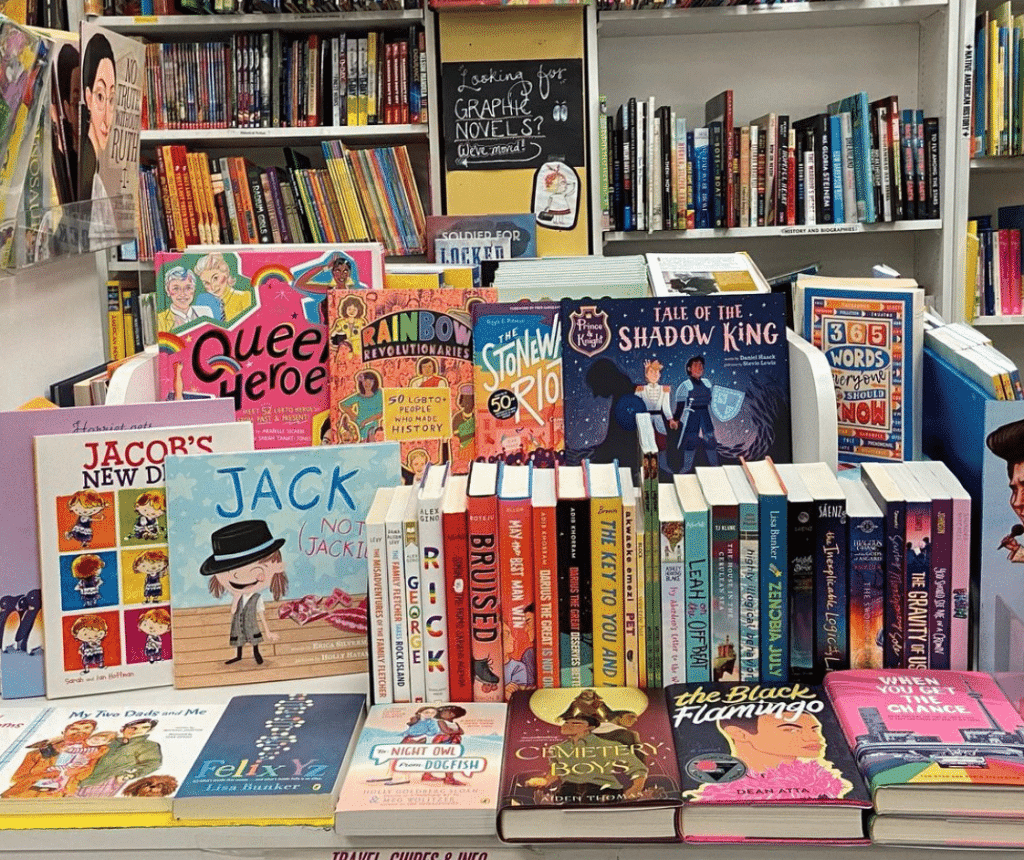 Collection of LGBTQ+ books at Child's Play for Pride Month